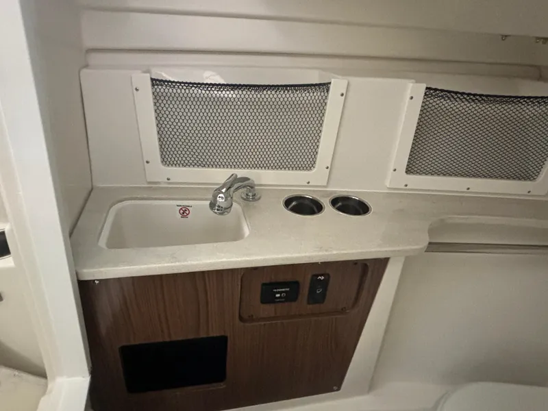 Slide: The Image of 2025 Sailfish 245 DC boat interior with sink and storage compartments. - 9