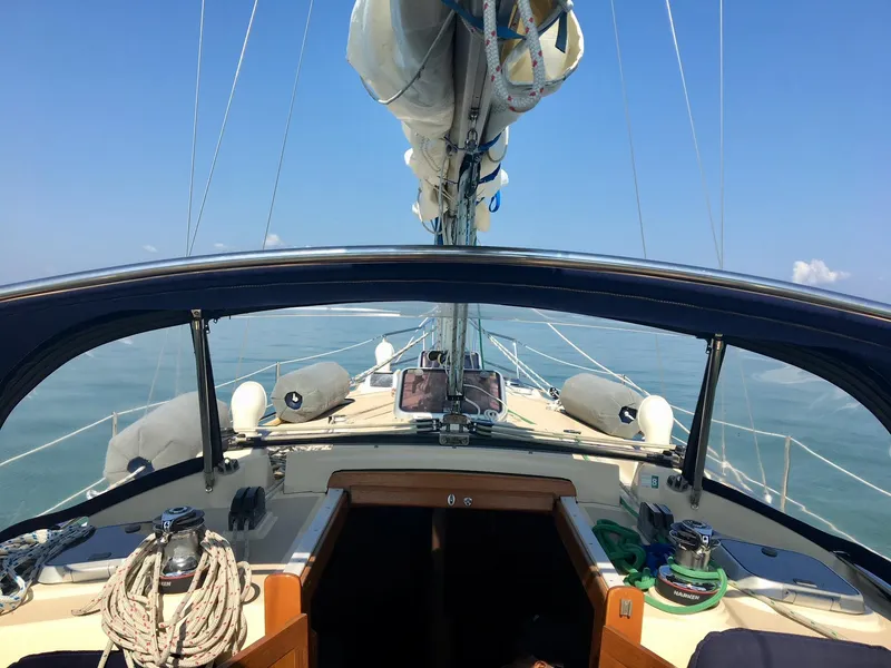 Slide: The Image of Island Packet 350 sailboat cockpit view, 1997 model, sailing on calm waters. - 10