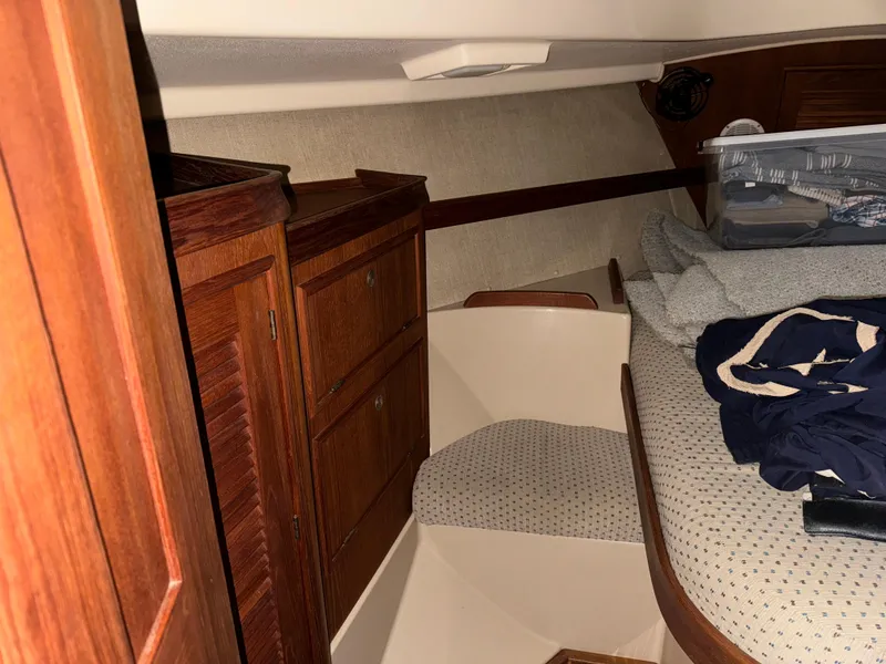 Slide: The Image of 1997 Island Packet 350 cabin interior with wooden cabinets and cozy sleeping area. - 19