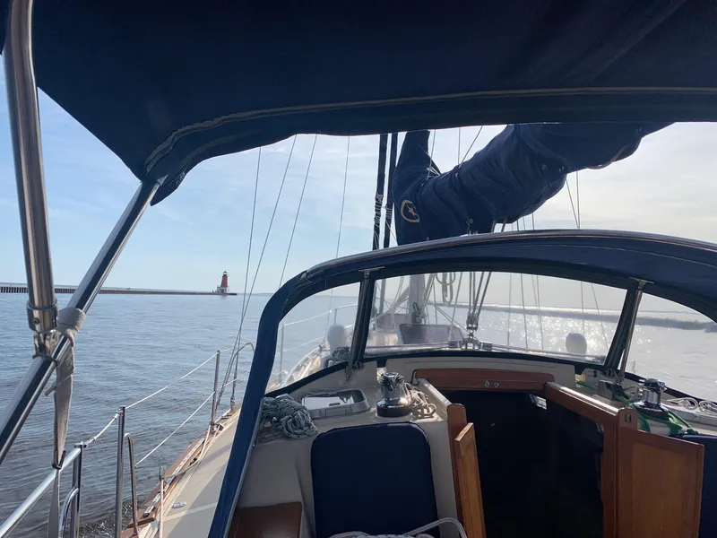 Slide: The Image of 1997 Island Packet 350 sailboat cockpit view with lighthouse in the distance. - 9