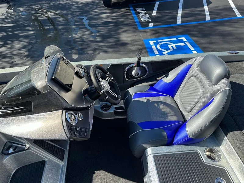 Slide: The Image of 2017 Ranger Z518 boat cockpit with blue and gray seating, steering wheel, and control panel. - 18
