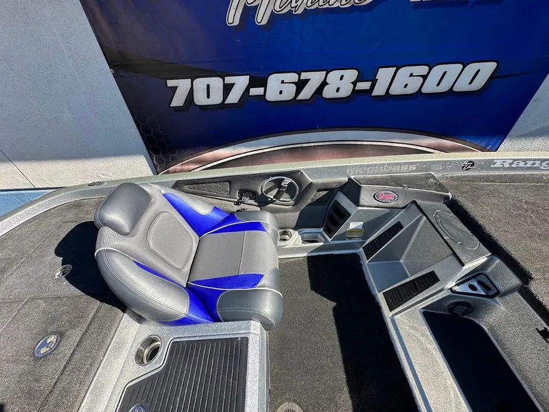 Slide: The Image of 2017 Ranger Z518 boat interior with blue and gray seating, dashboard, and controls. - 25