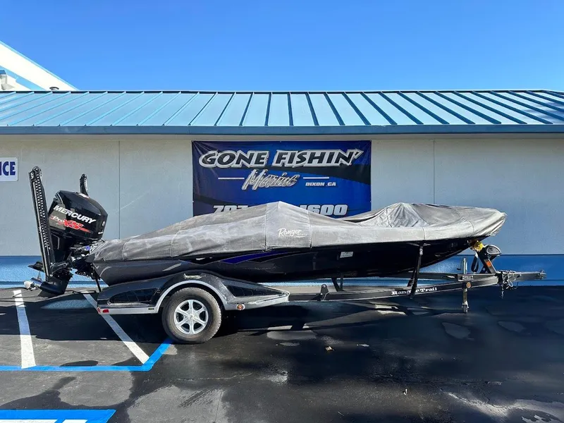 Slide: The Image of 2017 Ranger Z518 boat on trailer with cover, parked outside a fishing store. - 39