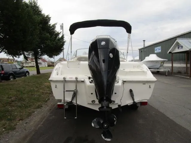 Slide: The Image of 2022 Key West 239 DFS boat with outboard motor, parked outdoors. - 10