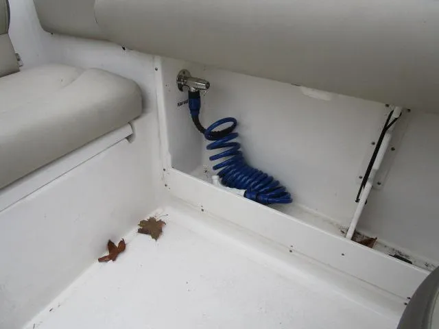 Slide: The Image of 2022 Key West 239 DFS boat interior with coiled blue hose and seating. - 22