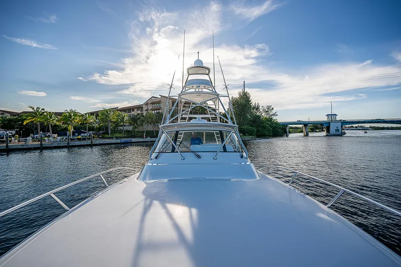 Slide: The Image of 2023 Viking 54 Open yacht on serene waterway under blue sky. - 12