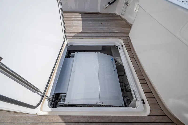 Slide: The Image of 2023 Viking 54 Open yacht engine compartment with open hatch on teak deck. - 20