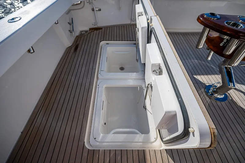 Slide: The Image of 2023 Viking 54 Open yacht deck with storage compartments and fishing rod holder. - 23