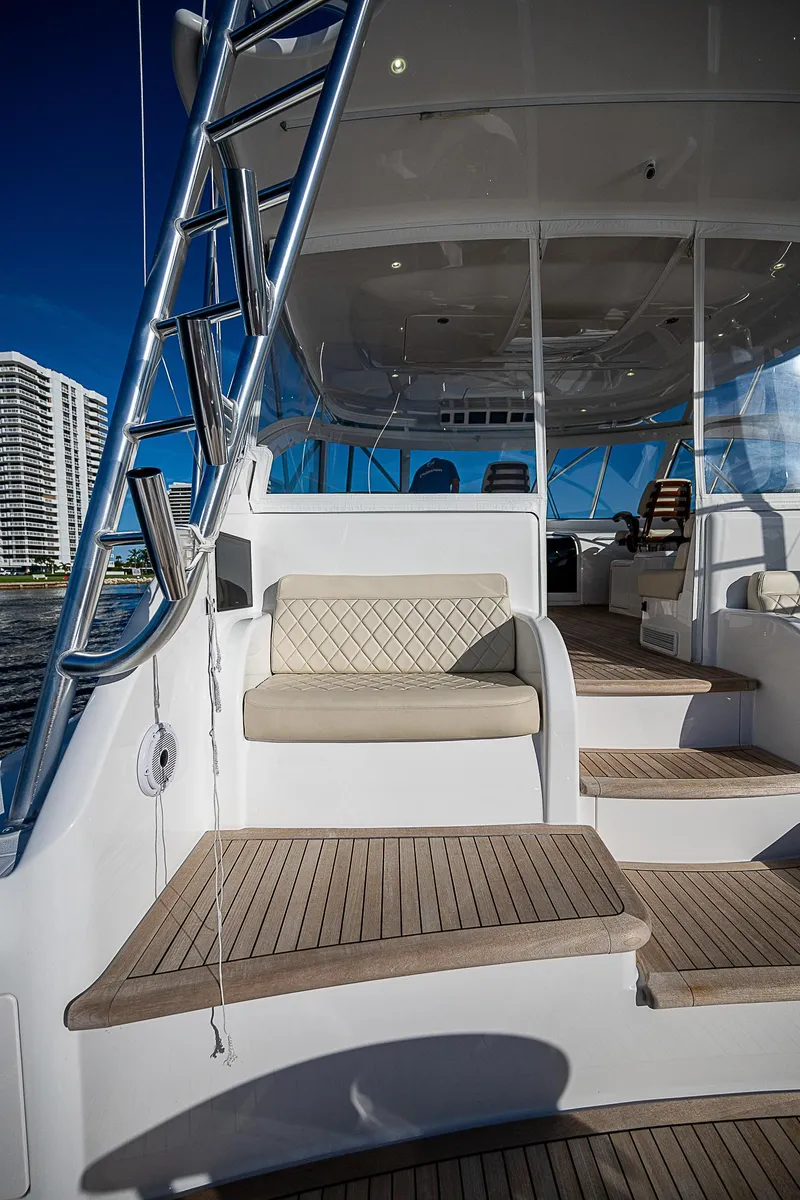 Slide: The Image of 2023 Viking 54 Open yacht interior with seating and wooden steps. - 25