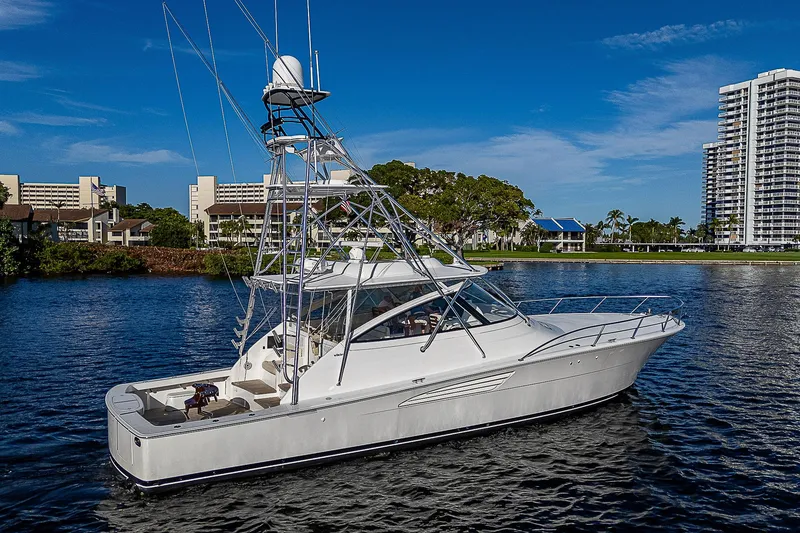 Slide: The Image of 2023 Viking 54 Open yacht on a calm river with cityscape background. - 3