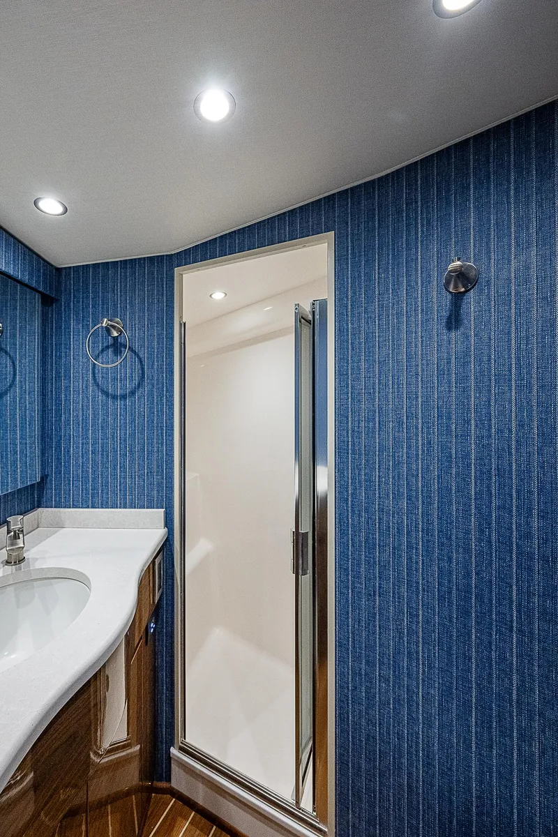 Slide: The Image of Luxurious bathroom in 2023 Viking 54 Open yacht with modern shower and blue walls. - 47
