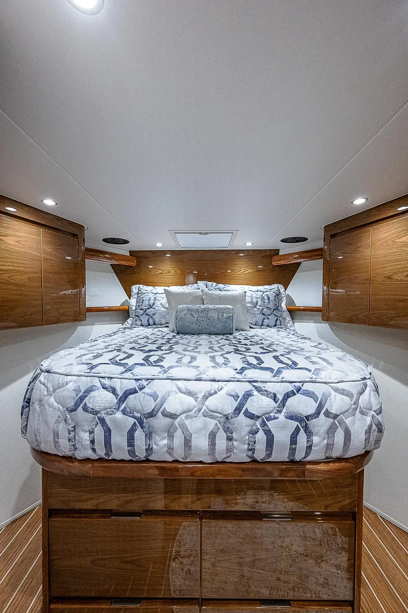 Slide: The Image of Luxurious bedroom interior of 2023 Viking 54 Open yacht with elegant bedding and wood accents. - 50