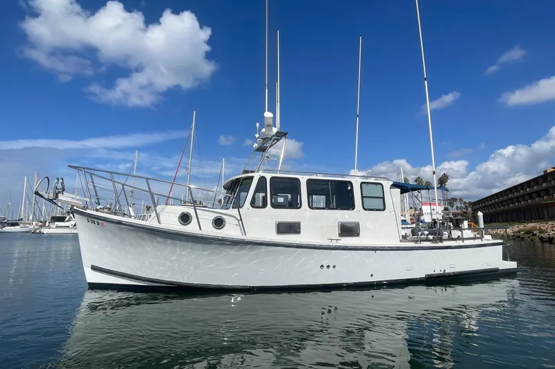 The Image of 1994 BHM Lobster Style CUSTOM boat docked in marina under blue sky. - 0