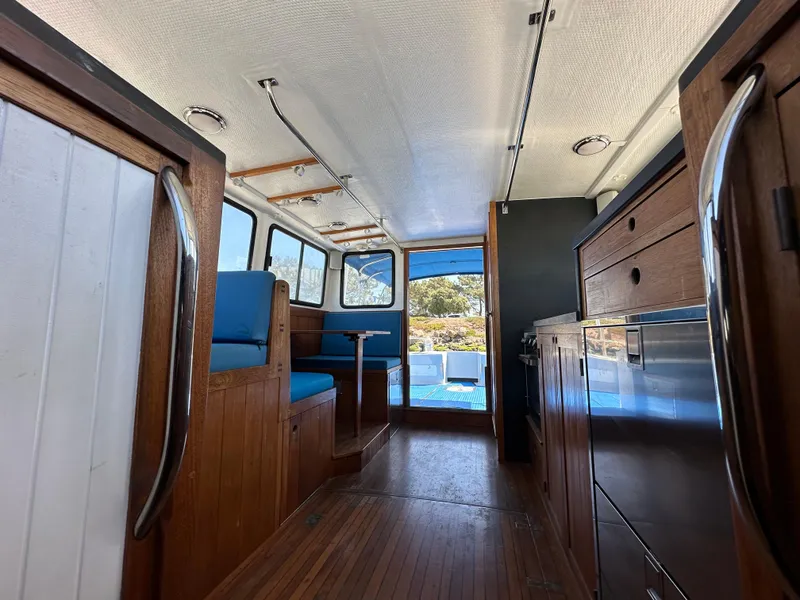 Slide: The Image of Interior of 1994 BHM Lobster Style CUSTOM boat with wooden cabinetry and kitchen area. - 9
