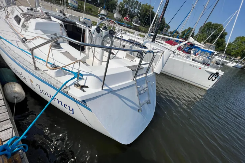 Slide: The Image of 1986 Hunter 31 sailboat docked in marina, sunny day, calm waters. - 10