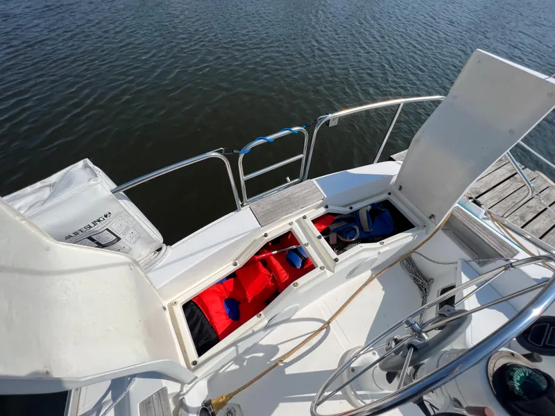 Slide: The Image of 1986 Hunter 31 sailboat cockpit with open storage compartments and life jackets. - 12