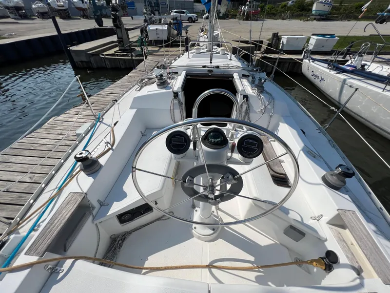 Slide: The Image of 1986 Hunter 31 sailboat cockpit with steering wheel and docked at marina. - 13