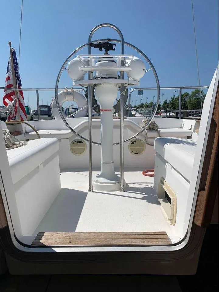 Slide: The Image of 1986 Hunter 31 sailboat cockpit with steering wheel and American flag. - 14