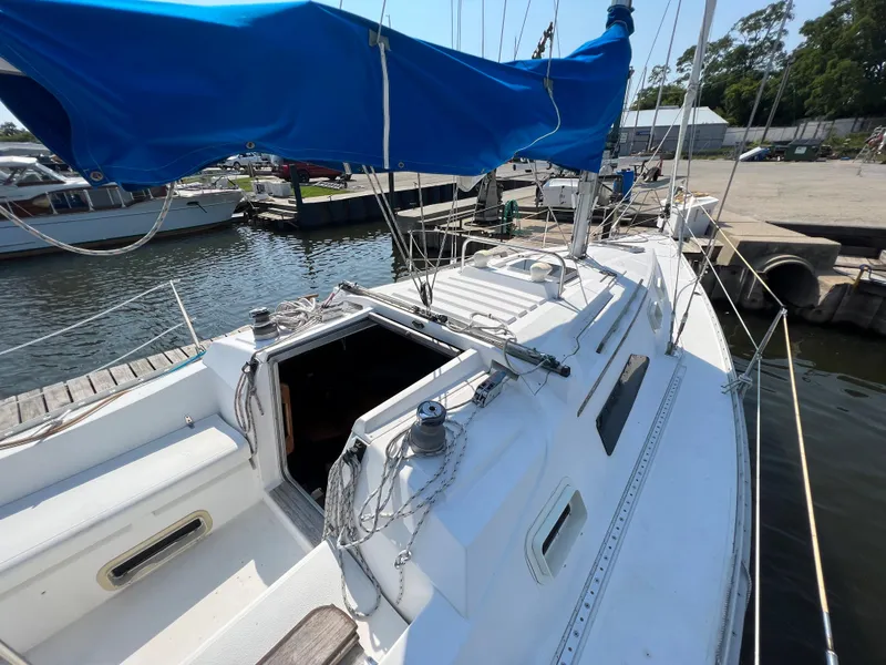 Slide: The Image of 1986 Hunter 31 sailboat with blue canopy docked at marina. - 15