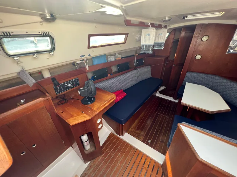 Slide: The Image of 1986 Hunter 31 sailboat interior with wood finish, seating, and navigation station. - 21
