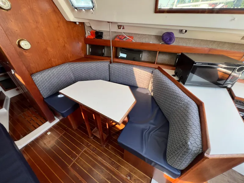 Slide: The Image of Interior of 1986 Hunter 31 sailboat with cozy dining area and wooden flooring. - 24