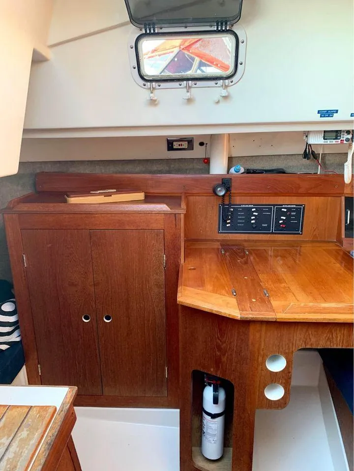Slide: The Image of 1986 Hunter 31 sailboat interior with wooden cabinetry and control panel. - 27