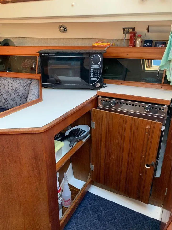 Slide: The Image of 1986 Hunter 31 yacht interior kitchen with microwave and wooden cabinetry. - 35