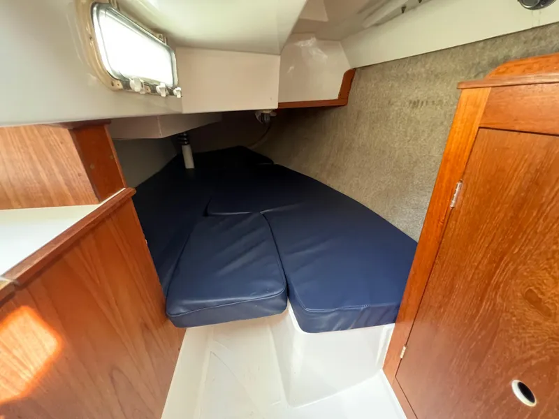 Slide: The Image of Interior cabin of 1986 Hunter 31 sailboat with blue cushions and wooden cabinetry. - 36