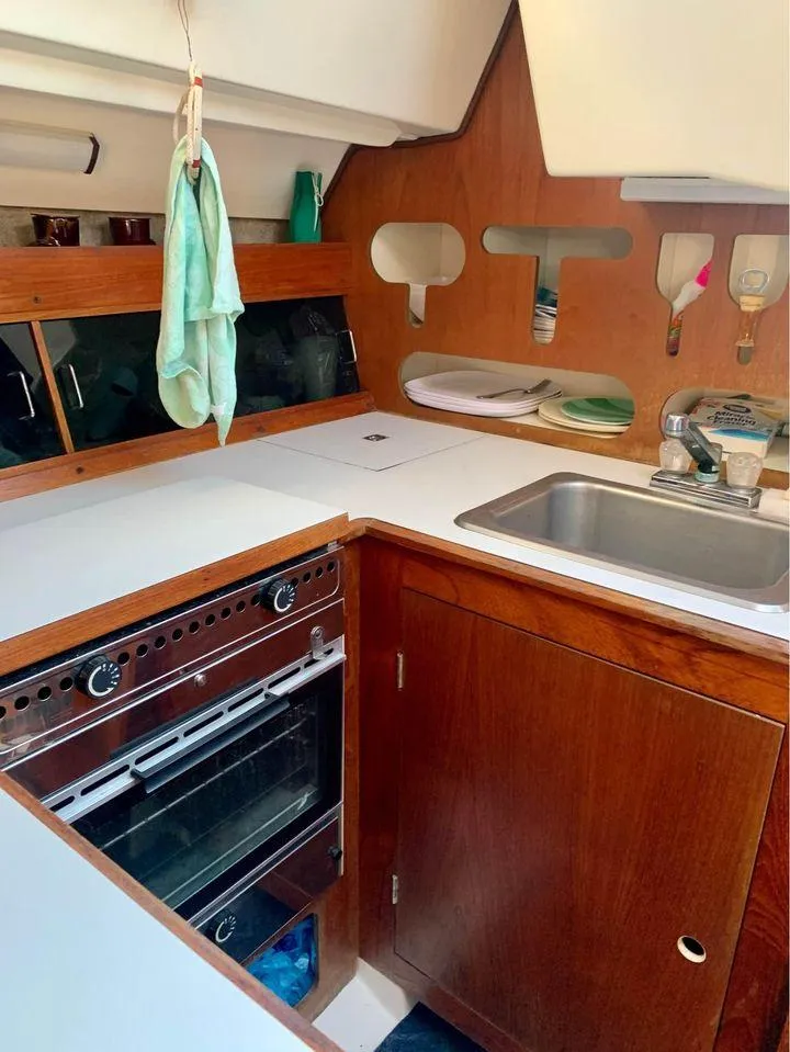 Slide: The Image of 1986 Hunter 31 sailboat kitchen with wood cabinetry and stainless steel sink. - 39