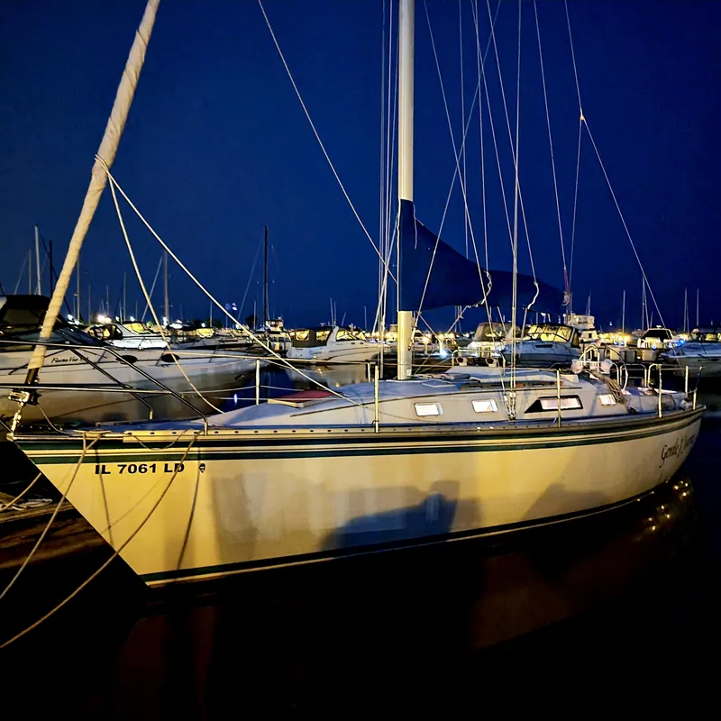 Slide: The Image of 1986 Hunter 31 sailboat docked at night, illuminated against a dark sky. - 40