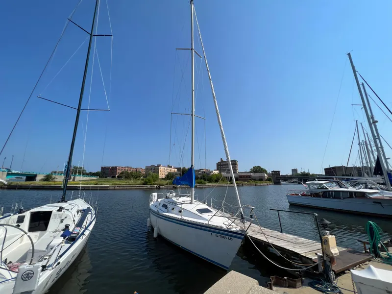 Slide: The Image of 1986 Hunter 31 sailboat docked in a sunny marina. - 5