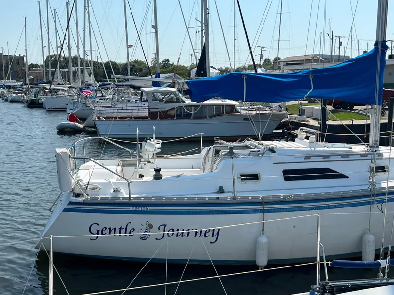 Slide: The Image of 1986 Hunter 31 sailboat "Gentle Journey" docked in a marina with blue sail cover. - 6