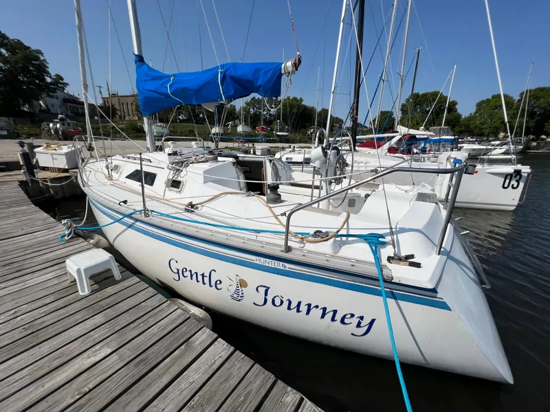 Slide: The Image of 1986 Hunter 31 sailboat "Gentle Journey" docked at marina with blue sail cover. - 9