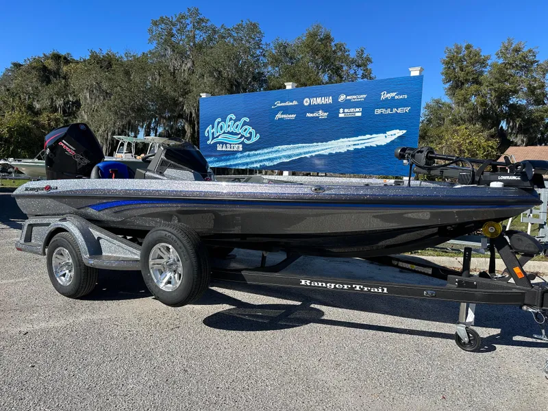 Slide: The Image of 2024 Ranger 518 Cup boat on trailer, parked outdoors with promotional signage in background. - 1