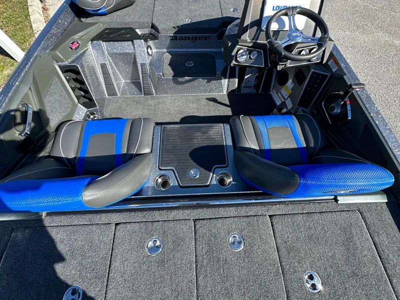 Slide: The Image of 2024 Ranger 518 Cup boat interior with blue and black seating, steering wheel, and storage compartments. - 10