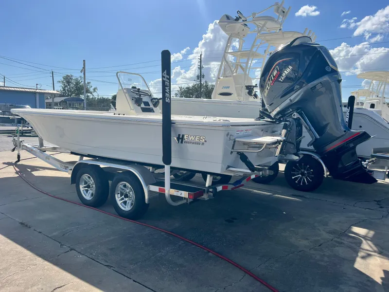 The Image of 2025 Hewes Redfisher 21 boat on trailer with powerful outboard motor. - 1