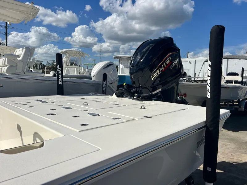 Slide: The Image of 2025 Hewes Redfisher 21 boat with powerful outboard motor under a blue sky. - 5