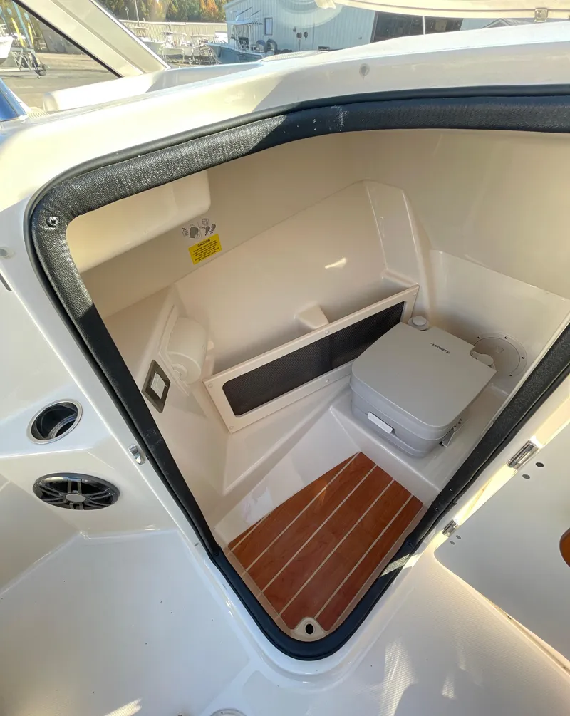 Slide: The Image of 2022 Grady-White Freedom 215 boat interior with compact toilet and wooden flooring. - 15