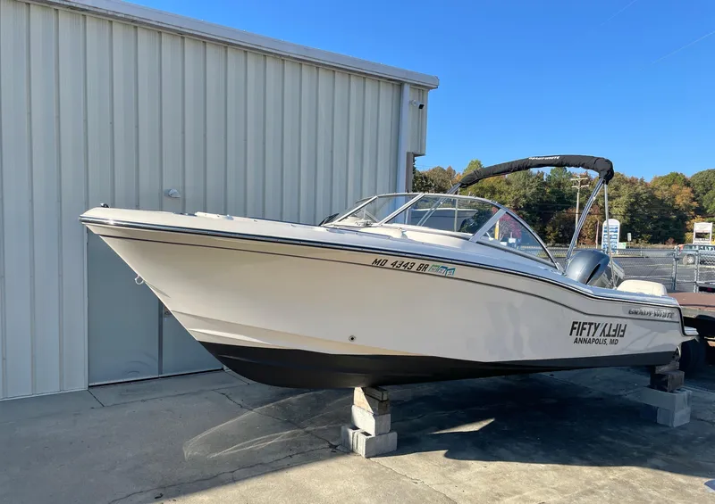 Slide: The Image of 2022 Grady-White Freedom 215 boat docked near a warehouse. - 2