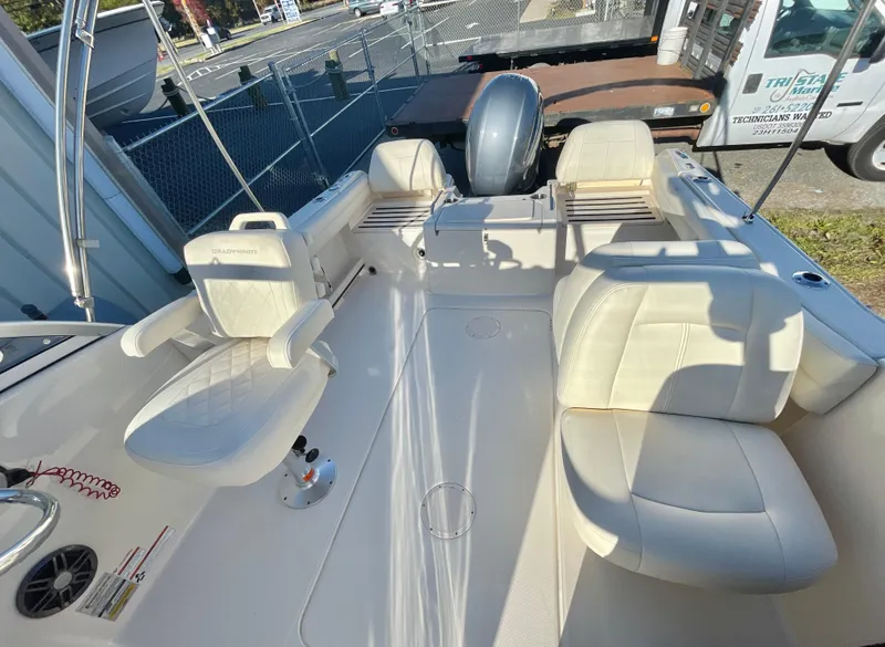 Slide: The Image of 2022 Grady-White Freedom 215 boat interior with seating and motor, parked outdoors. - 6