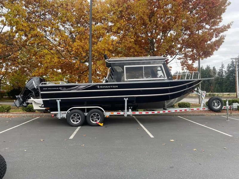 The Image of 2025 Spartan 26 Maximus boat on trailer, parked in autumn setting. - 1