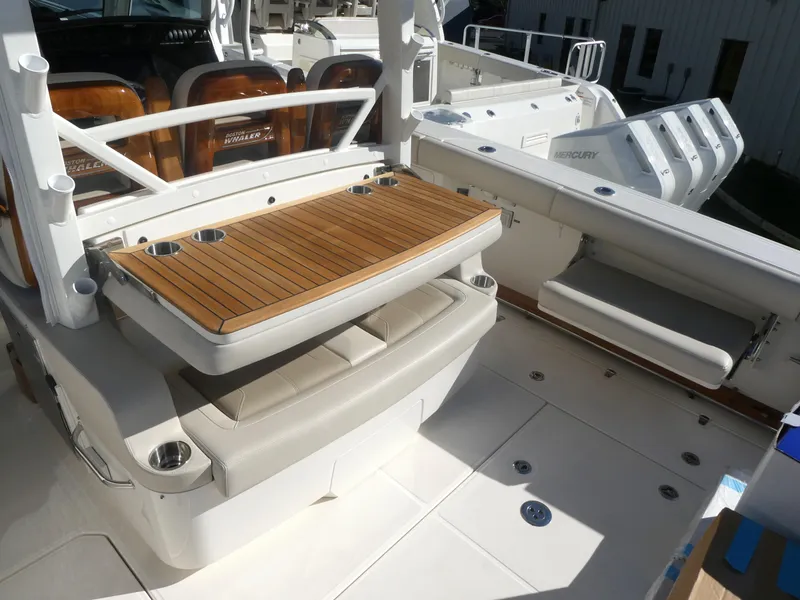 Slide: The Image of 2025 Boston Whaler 380 Outrage boat deck with seating and wooden table. - 5