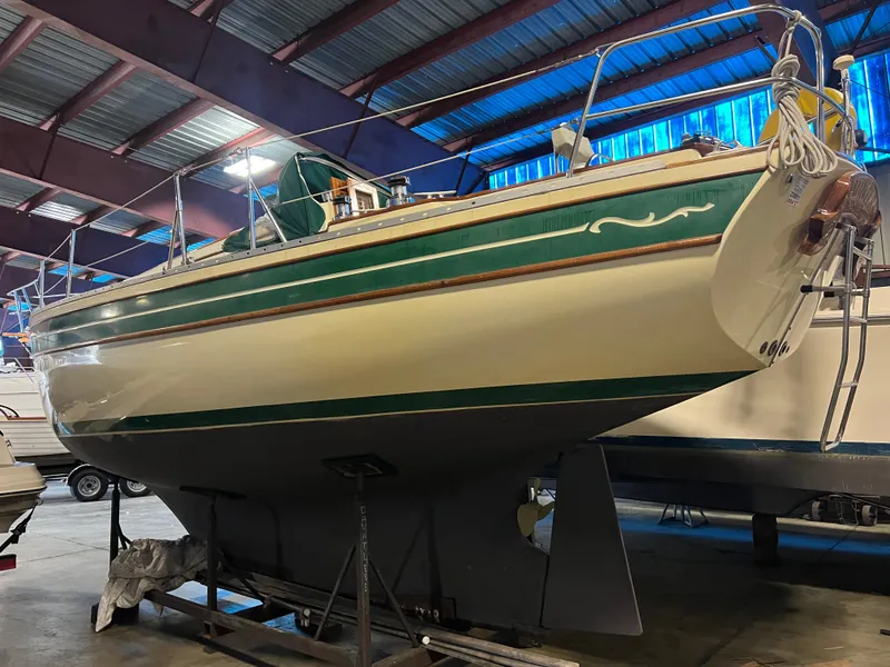 Slide: The Image of 1987 Bayfield 32C sailboat in a warehouse, green and white hull, on a stand. - 11