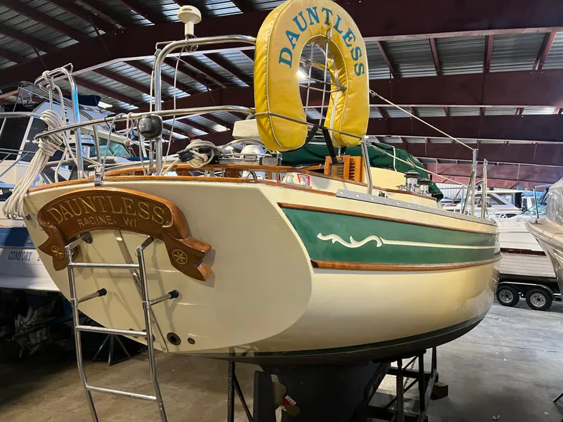 Slide: The Image of 1987 Bayfield 32C sailboat "Dauntless" in storage, featuring green accents and a yellow life ring. - 12
