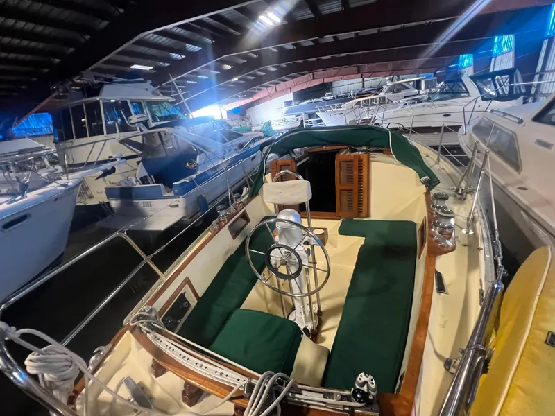 Slide: The Image of 1987 Bayfield 32C sailboat with green seating, docked indoors among other boats. - 13