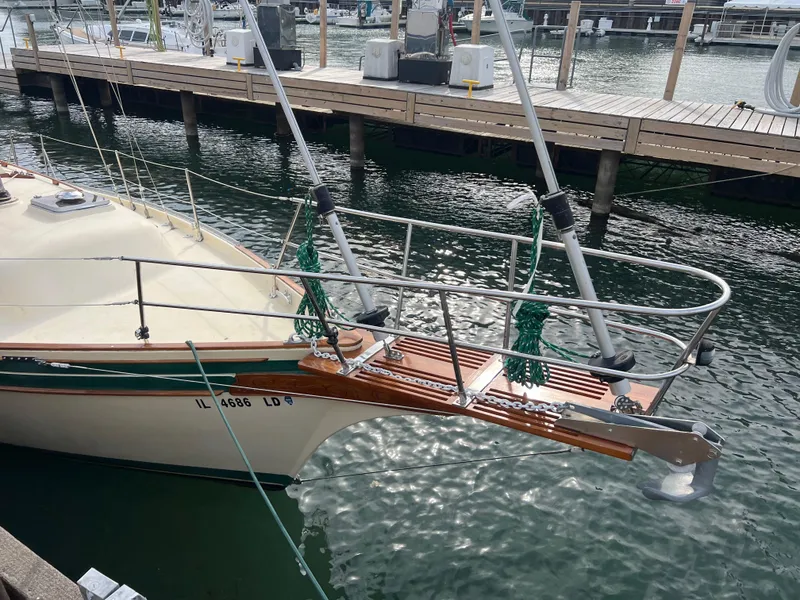 Slide: The Image of 1987 Bayfield 32C sailboat docked at marina, featuring classic design and wooden accents. - 2