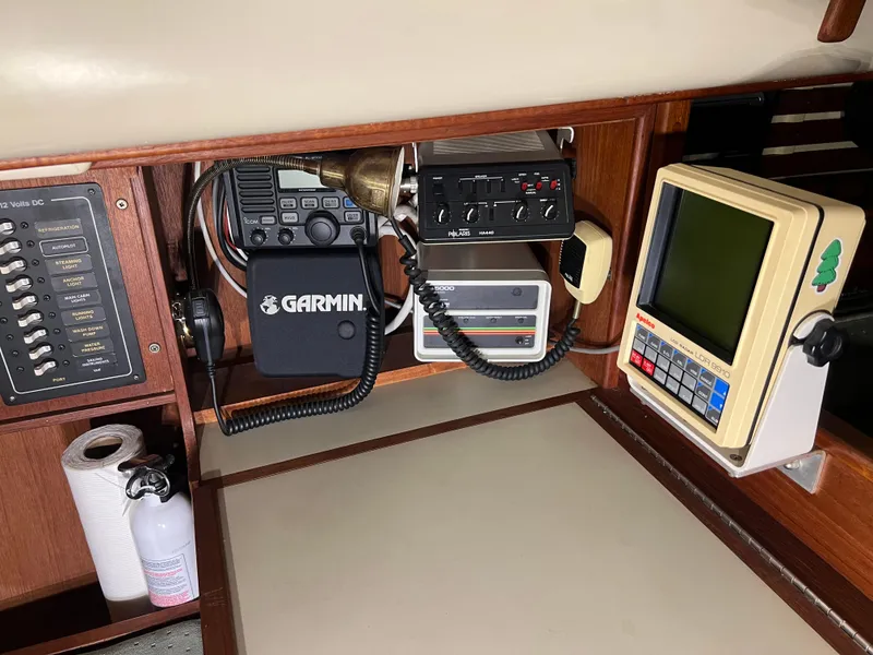 Slide: The Image of Navigation equipment in a 1987 Bayfield 32C sailboat, featuring Garmin devices and control panels. - 22