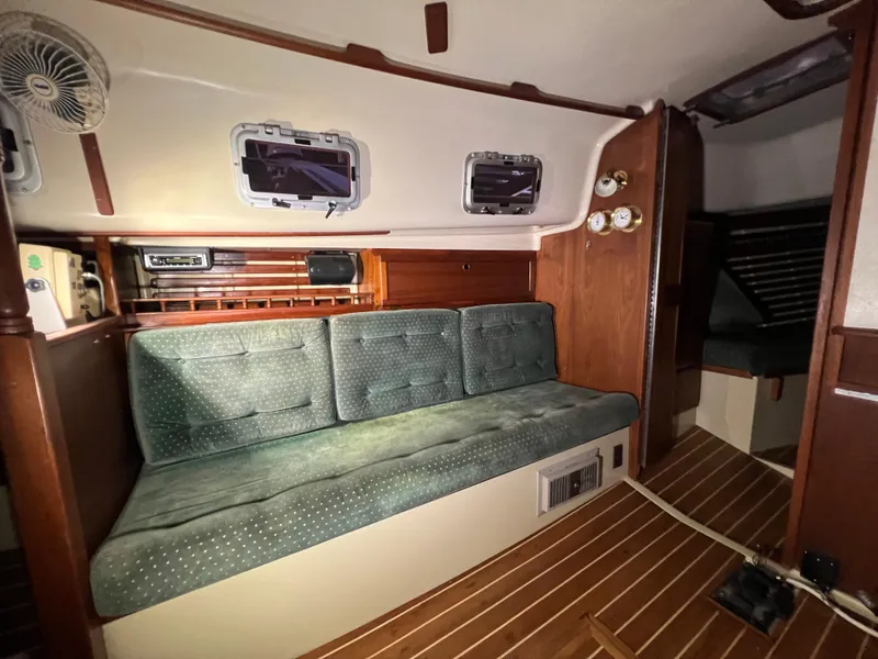 Slide: The Image of Interior of 1987 Bayfield 32C sailboat with green cushioned seating and wooden accents. - 27