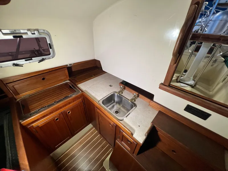 Slide: The Image of 1987 Bayfield 32C yacht interior kitchen with wooden cabinets and stainless steel sink. - 28