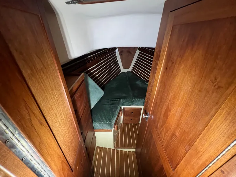 Slide: The Image of 1987 Bayfield 32C sailboat cabin with wooden interior and green cushions. - 30